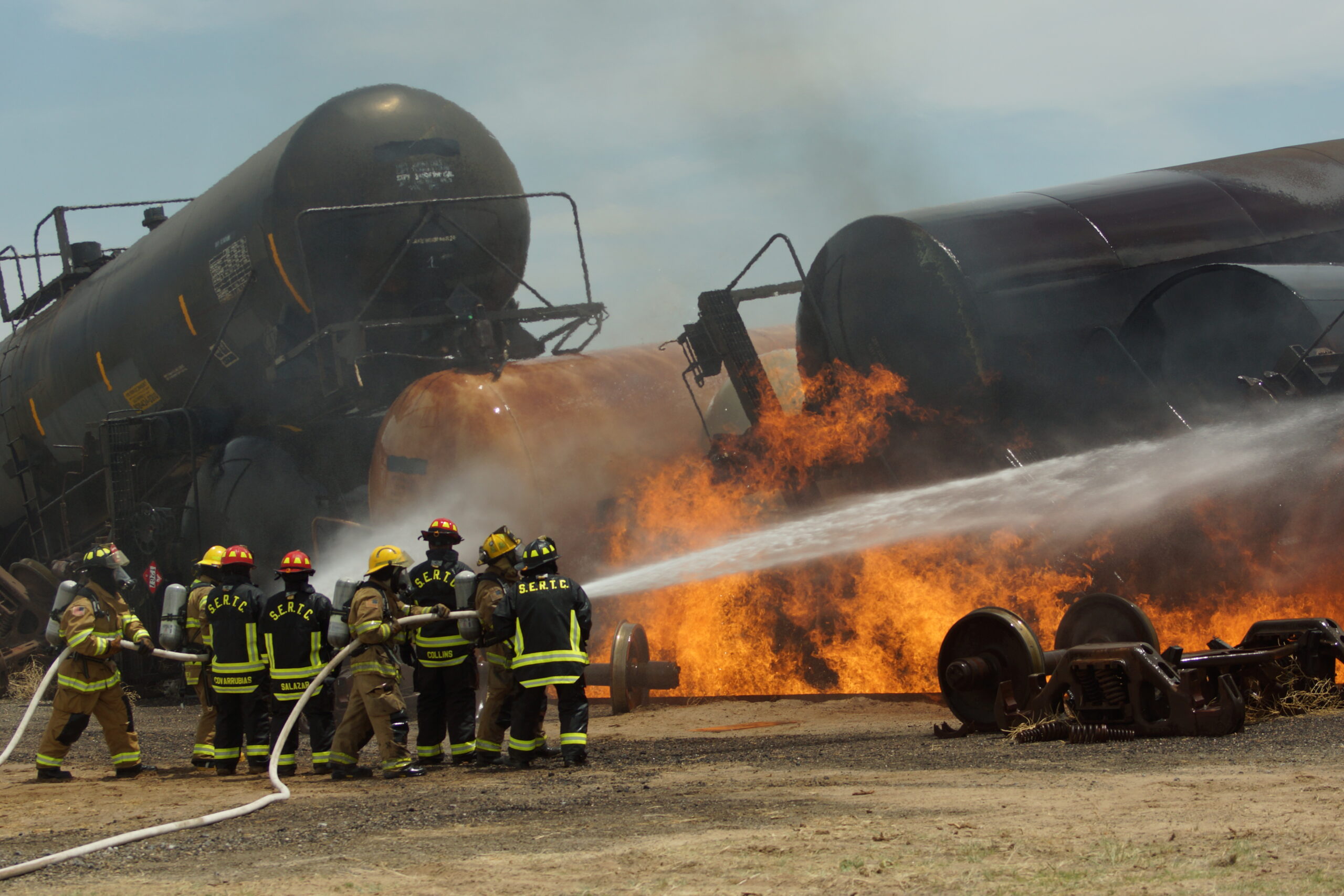 Firefighters training on a full-scale simulated derailment with live fire.